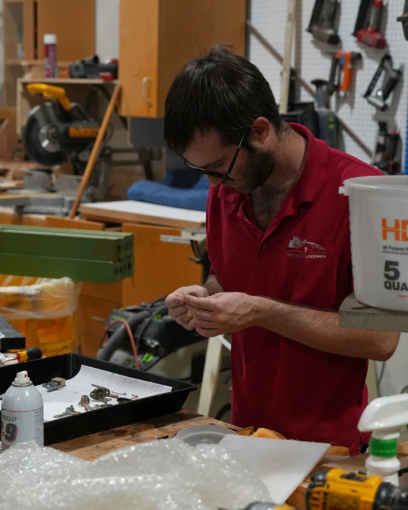 Red Rocks Locksmith technician working on an antique lock component at the workshop bench