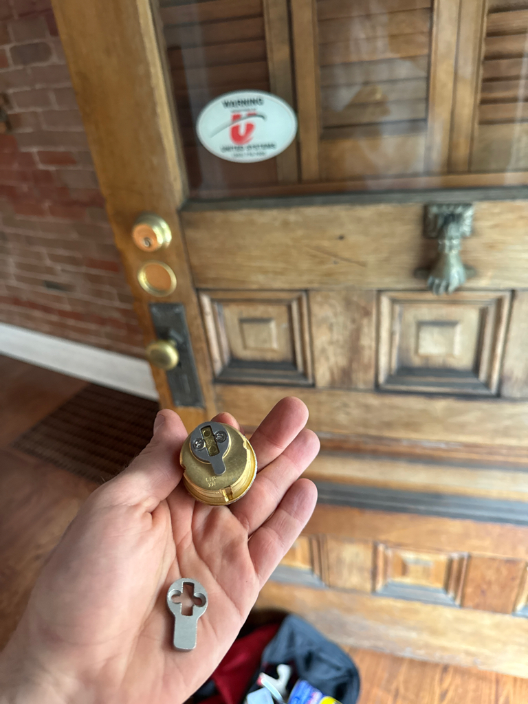 Brass keyed lock, knob, and mortise-style edge hardware on an older residential door in Denver - view 4