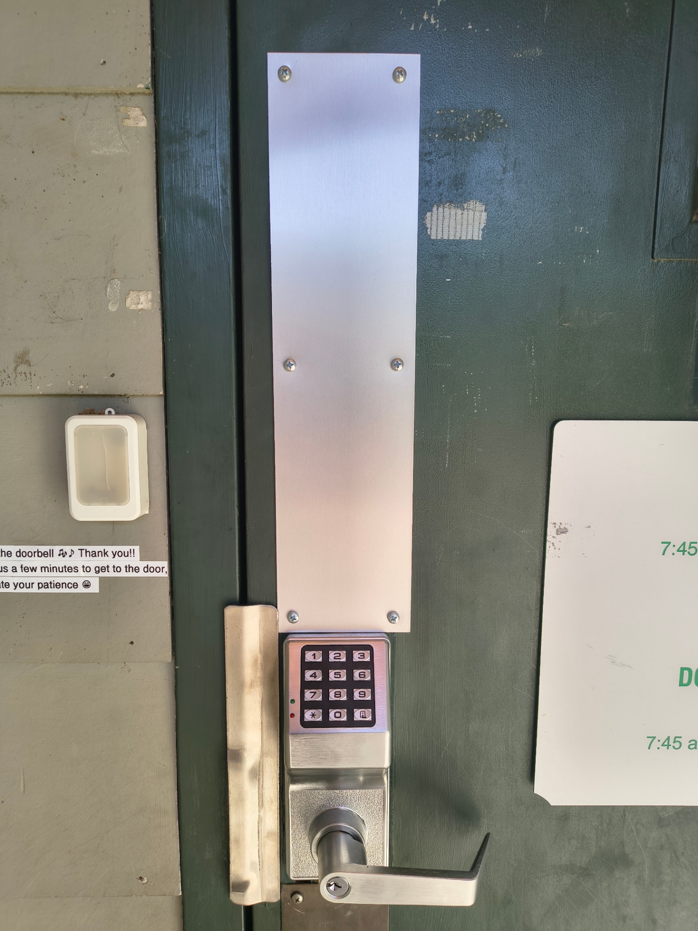 Mounted black commercial keypad lock with silver lever and long protective plate on a worn green door in Boulder - view 5