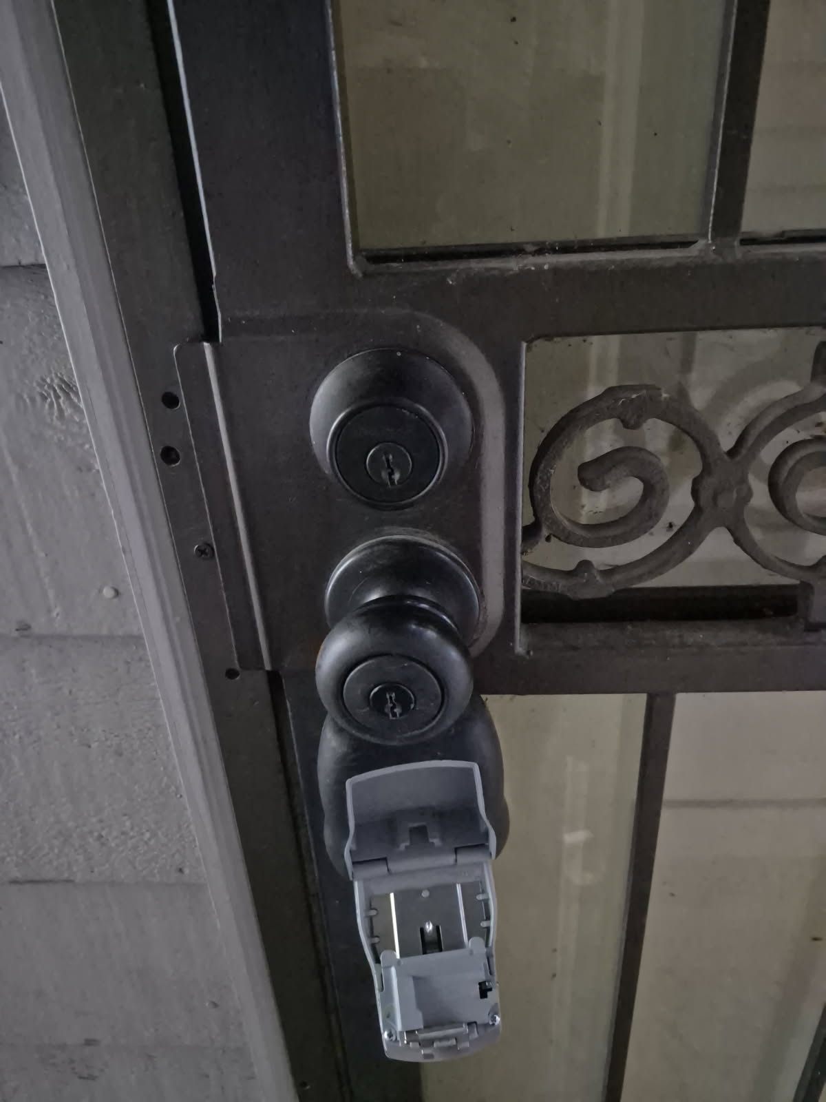 Residential Lakewood entry door with an upper deadbolt, lower lockset, glass panels, and decorative metalwork