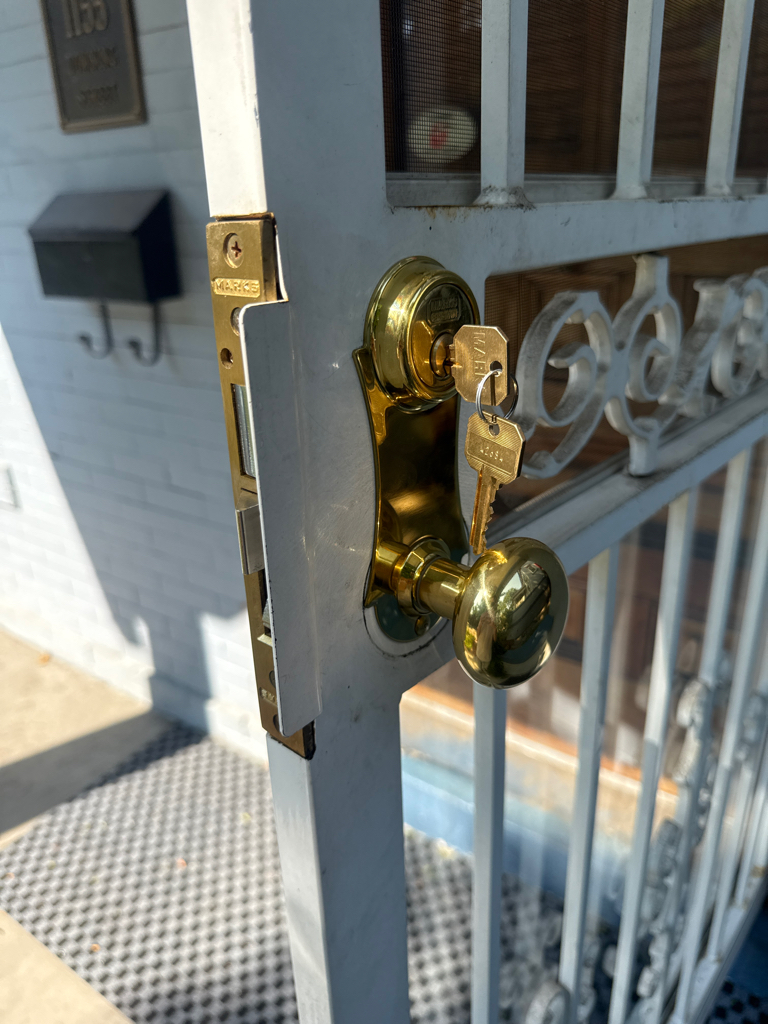 Brass keyed lock, knob, and mortise-style edge hardware on an older residential door in Denver