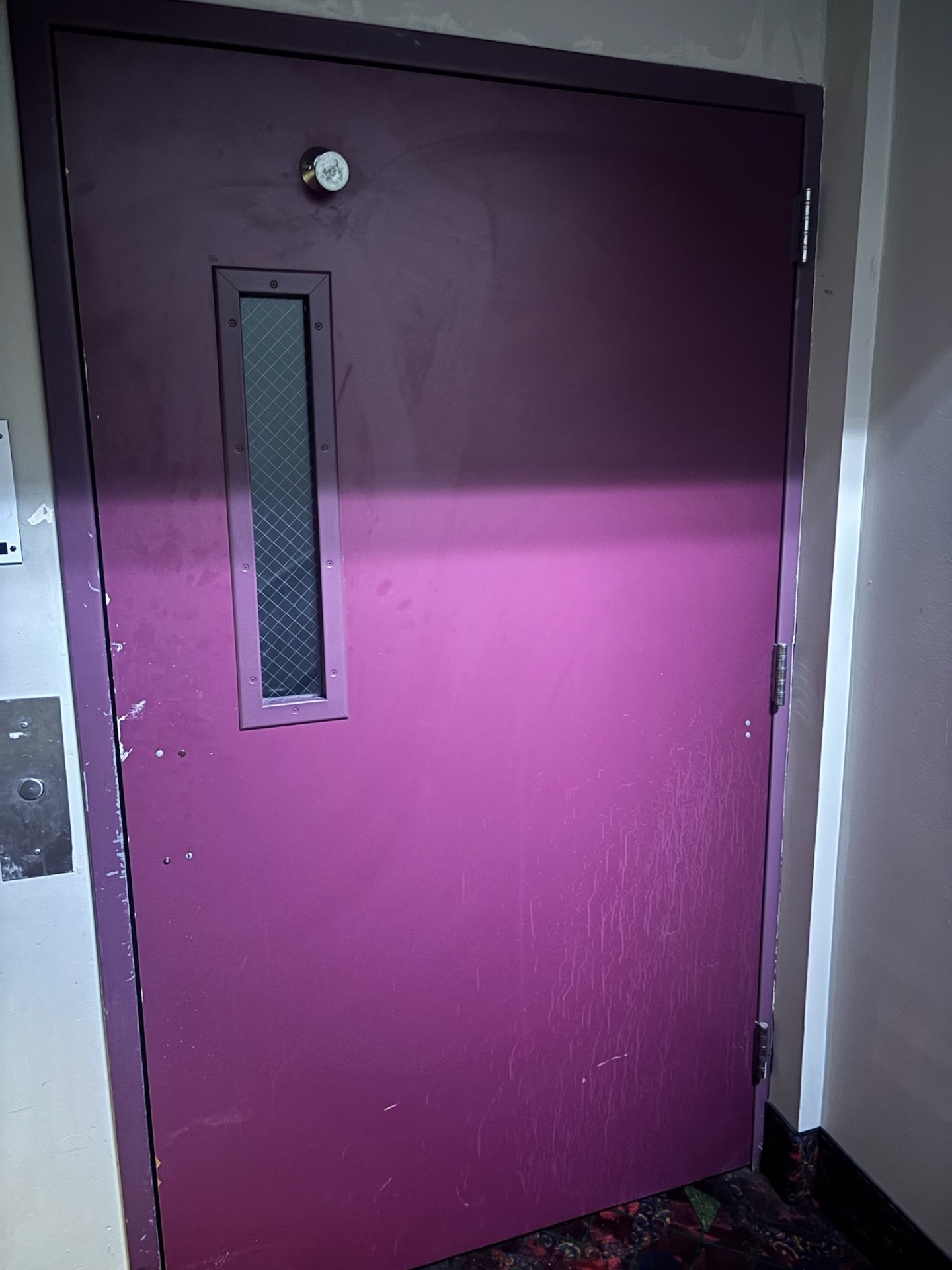 Burgundy commercial exit door in a Denver facility with a narrow wired-glass vision panel, panic bar, and brushed-metal lock escutcheon - view 3