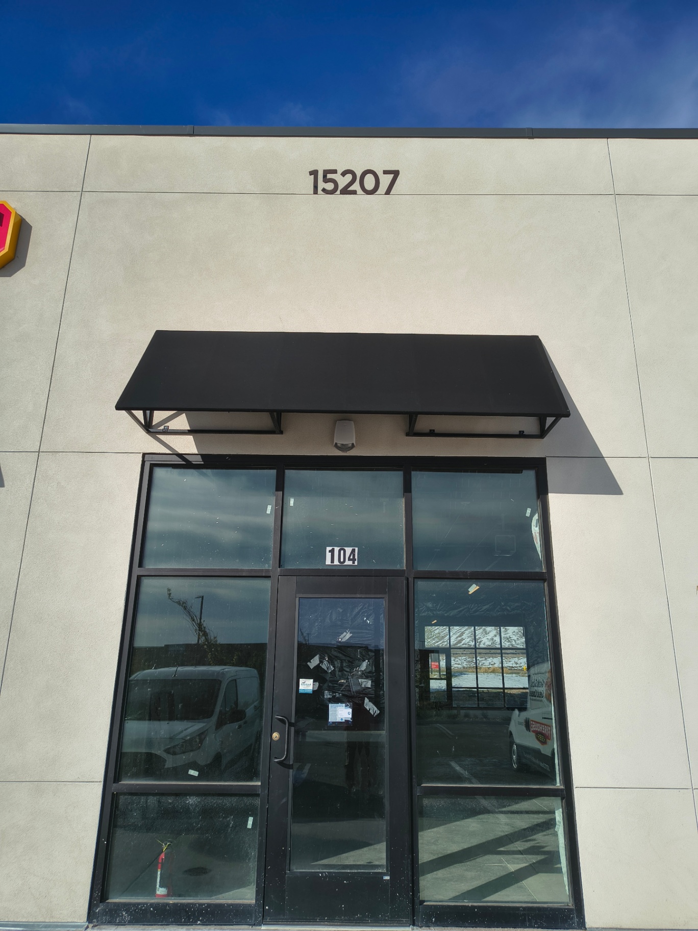 Black-framed commercial glass entrance in Arvada with pull handles and visible keyed lock cylinders