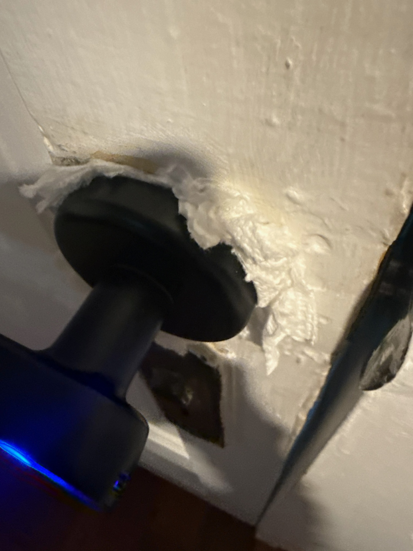 Close-up of a black blue-illuminated electronic keypad lever lock above separate lower lock hardware on a white paneled door in Boulder - view 3