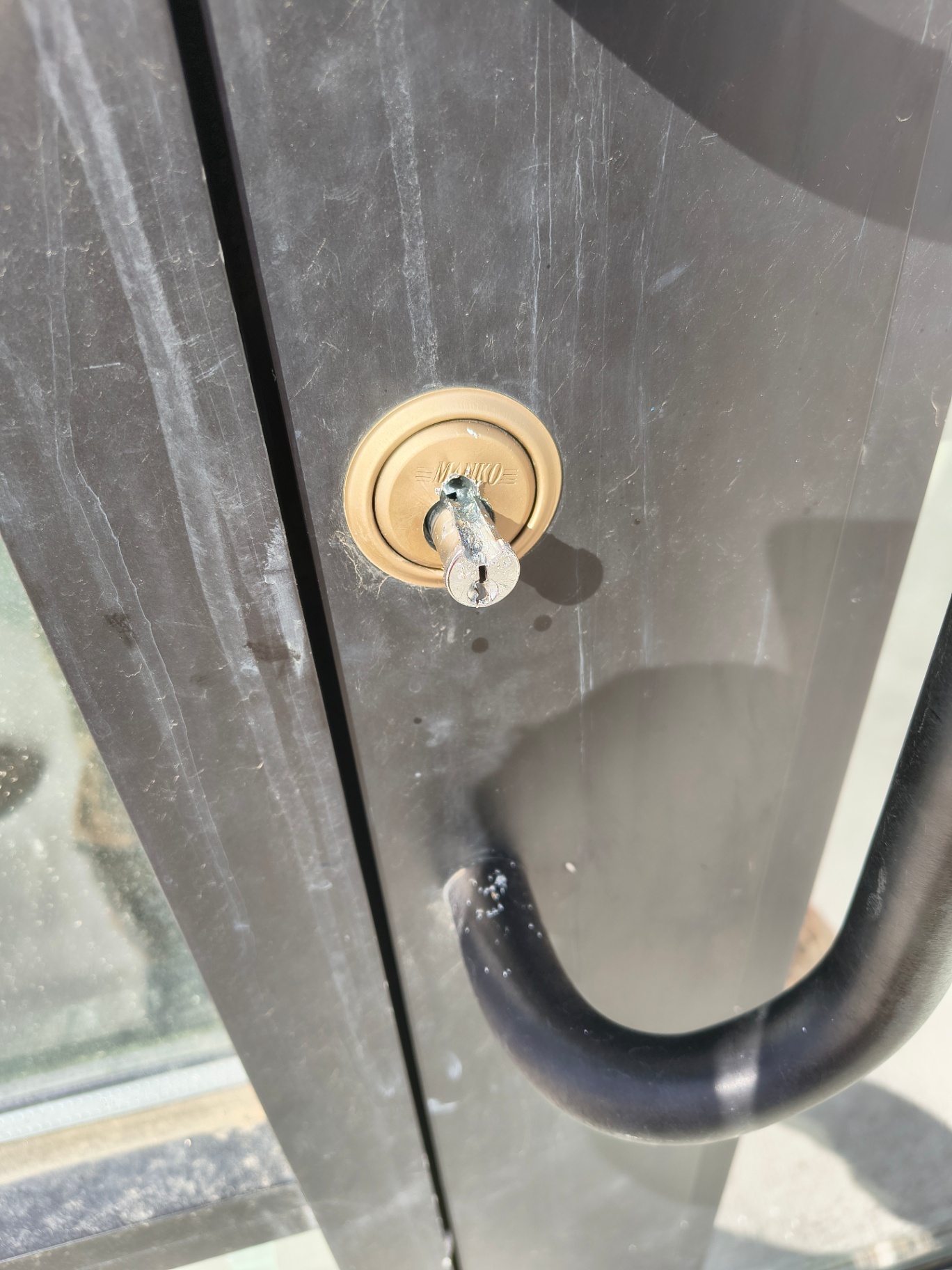 Black-framed commercial glass entrance in Arvada with pull handles and visible keyed lock cylinders - view 7