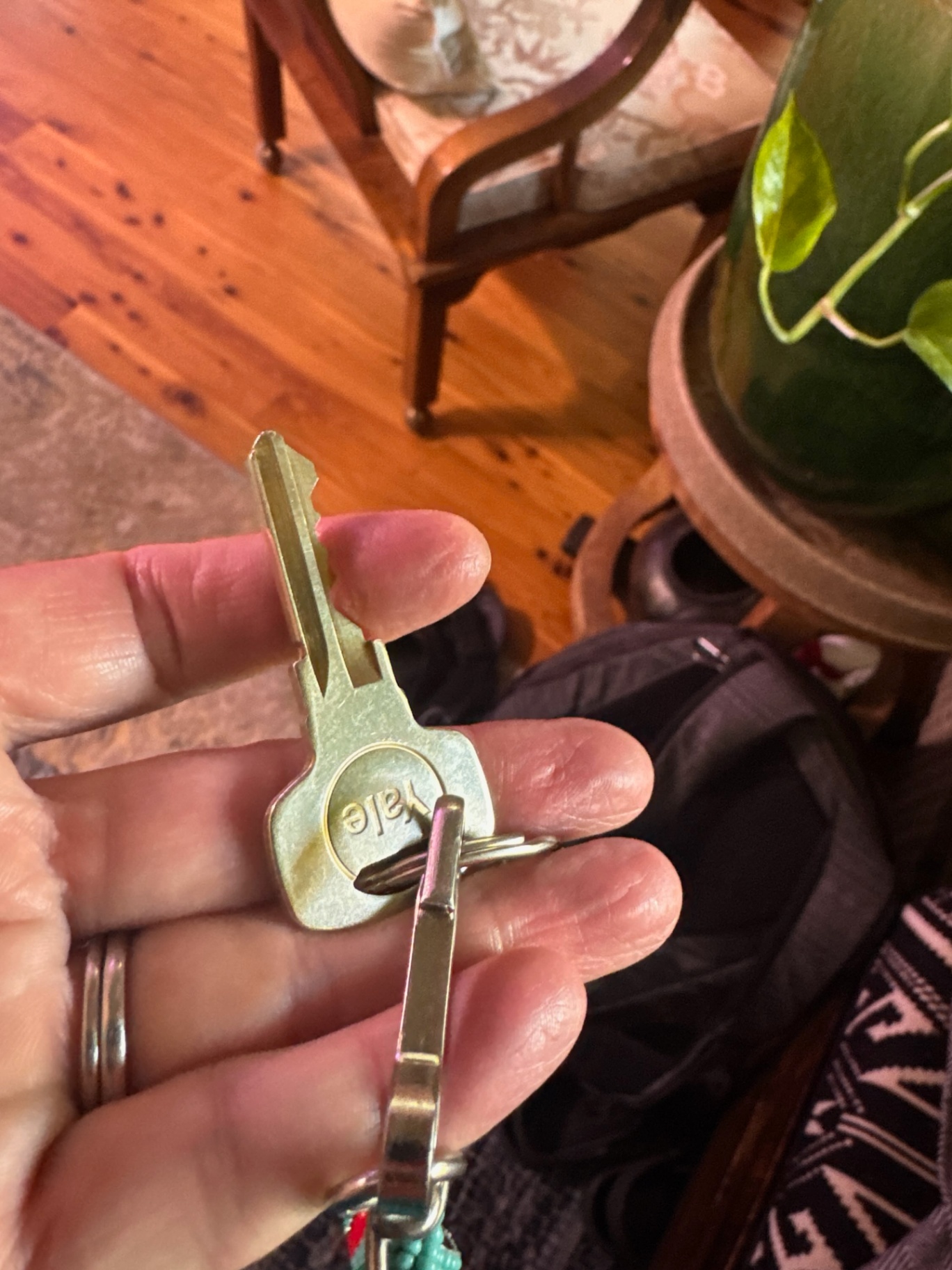 Hand holding two keys indoors for a Boulder house lock change and rekey service.