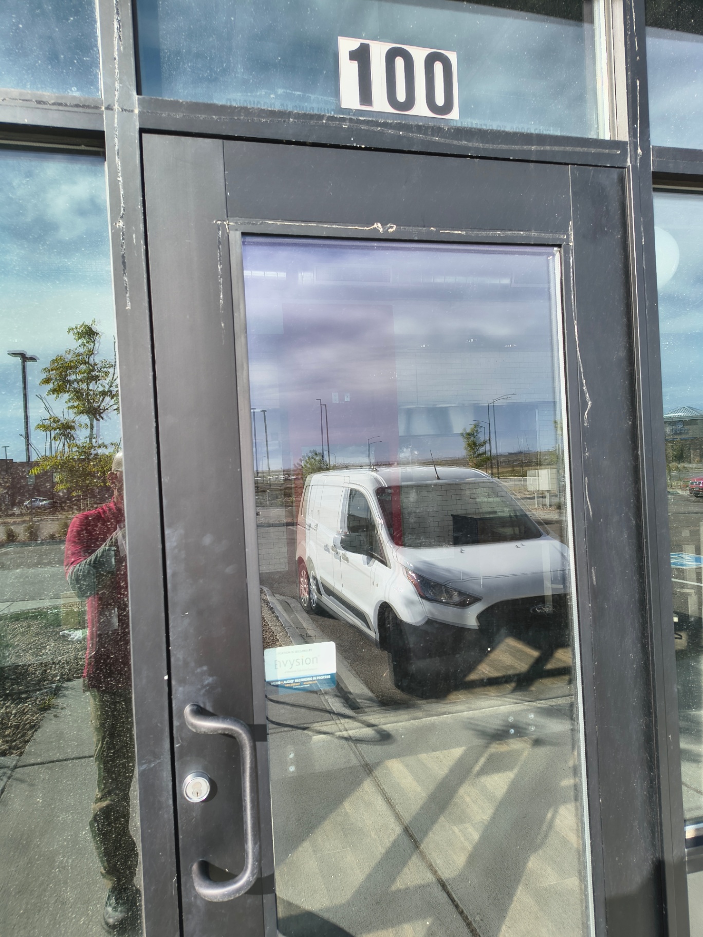 Black-framed commercial glass entrance in Arvada with pull handles and visible keyed lock cylinders - view 3