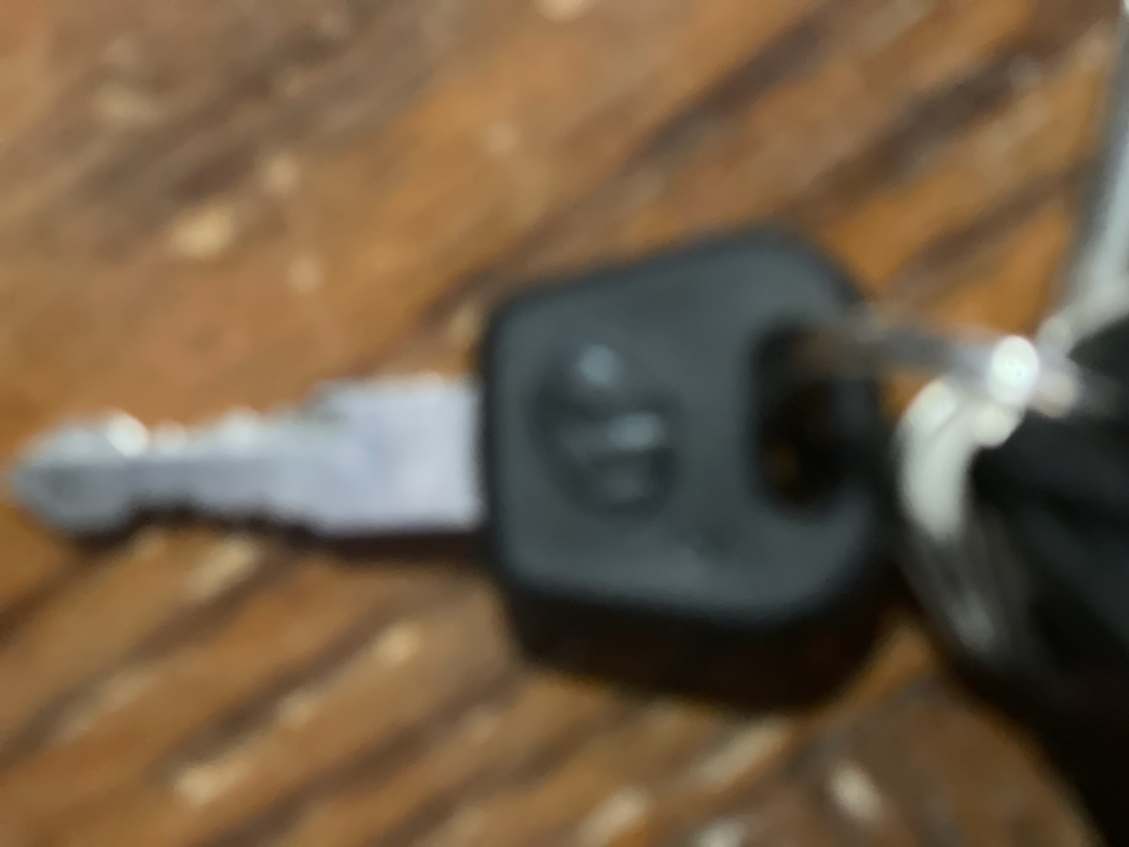 Close-up of a keyed cylinder integrated into the black battery housing of an electric bicycle in an indoor workshop.